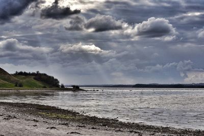 Scenic view of sea against storm clouds