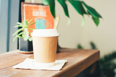 Coffee in disposable cup on table at cafe