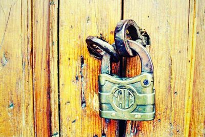 Close-up of rusty chain on wooden door