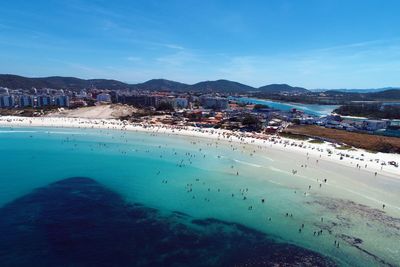 Panoramic view of sea and city against blue sky