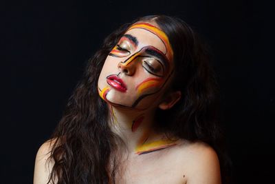 Portrait of a beautiful young woman over black background