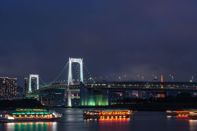 View of bridge over river in city at night