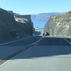 Road by mountain against clear sky