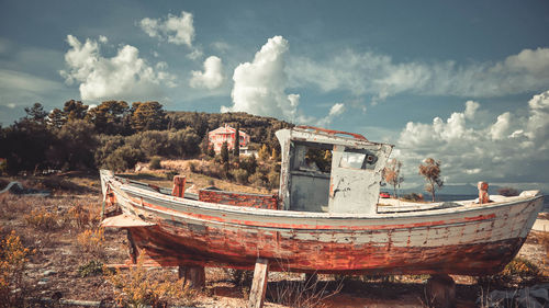 Abandoned boat on shore against sky