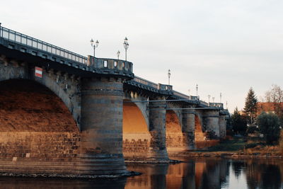 Arch bridge over river against sky