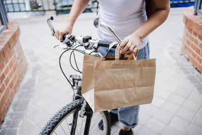 Midsection of delivery person with bicycle