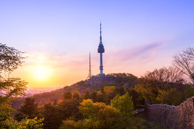 Tower and buildings against sky during sunset