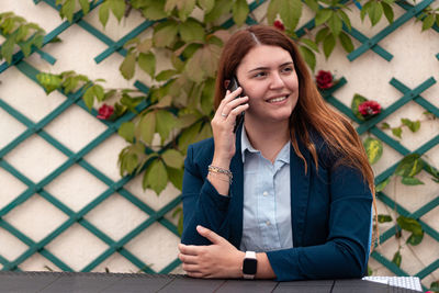 Portrait of young woman using mobile phone outdoors