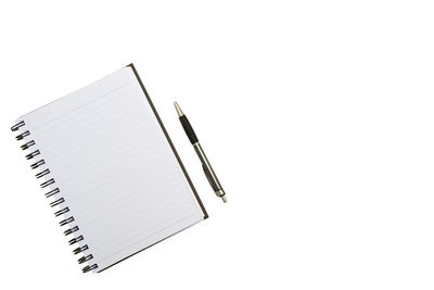 Directly above shot of spiral notebook with pen on white background