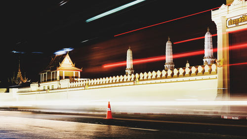 Light trails on illuminated building at night