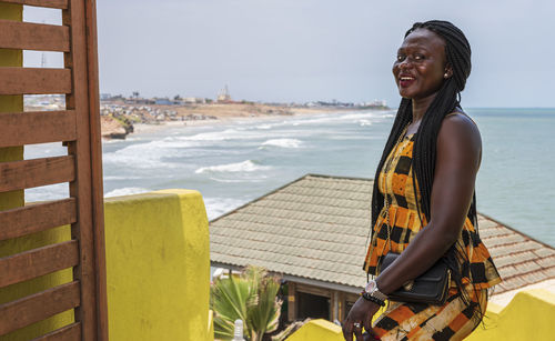 Africa woman from ghana is happy at an entrance to a seafront restaurant in accra ghana west africa.