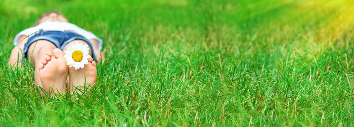 Low section of woman standing on grassy field