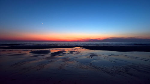 Scenic view of sea against clear sky during sunset