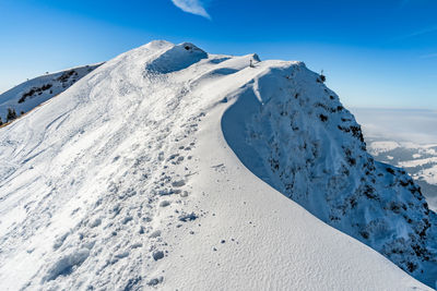 Snow covered mountain against blue sky