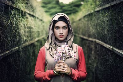 Portrait of beautiful woman holding flowers