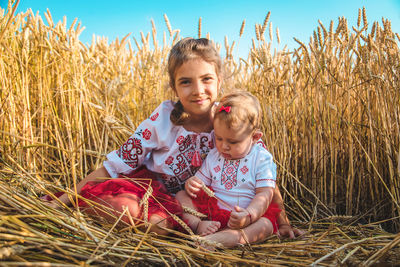 Girl sitting with sister in field
