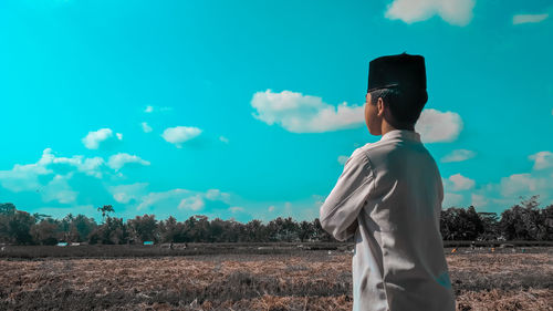 Man standing on field against sky