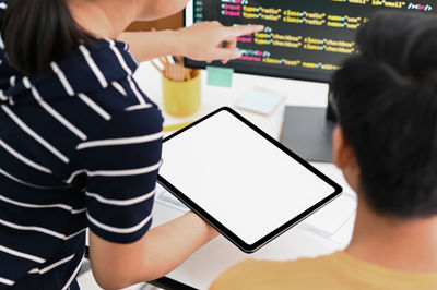 Rear view of man and woman using mobile phone