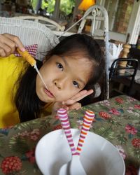 Portrait of girl eating food at table in restaurant