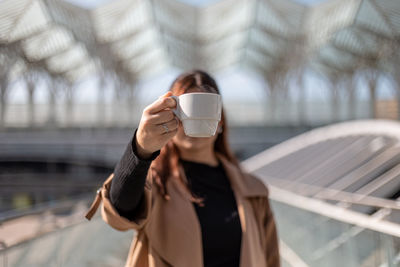 Midsection of man holding coffee cup