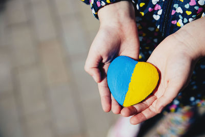 Midsection of woman holding heart shape