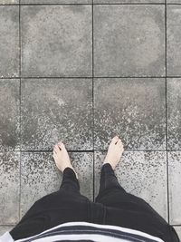 Low section of man standing on tiled floor