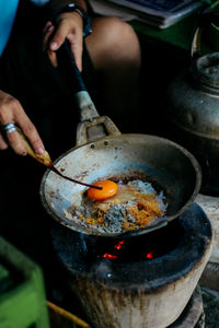 Midsection of person preparing food on barbecue grill