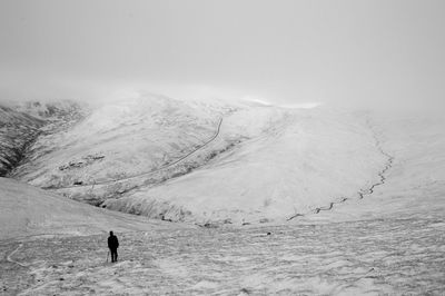 Person standing on snow covered landscape