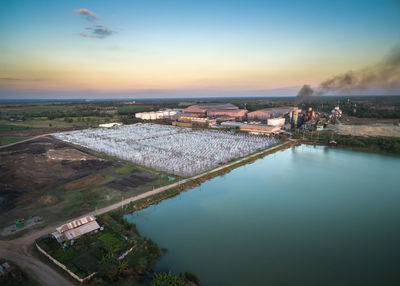 High angle view of river amidst buildings in city at sunset