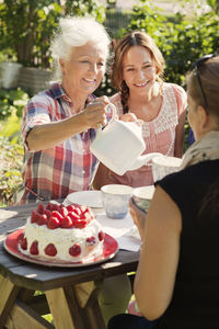 Four women enjoying cake and tea in garden