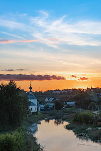 Buildings and trees against sky during sunset