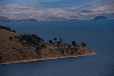 Scenic view of sea and mountains against sky