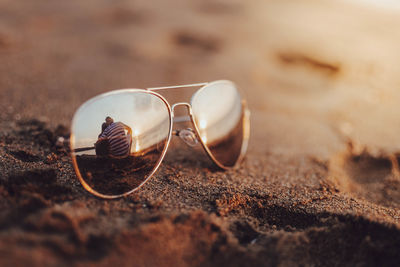 Close-up of sunglasses on sand