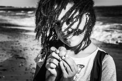 Portrait of woman holding umbrella at beach