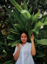 Portrait of woman standing amidst plants