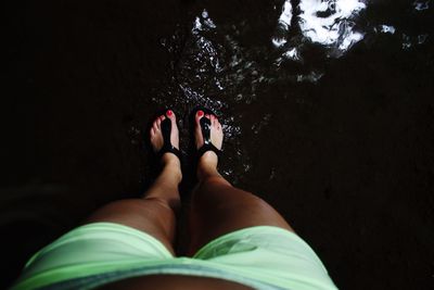 Low section of woman standing in water