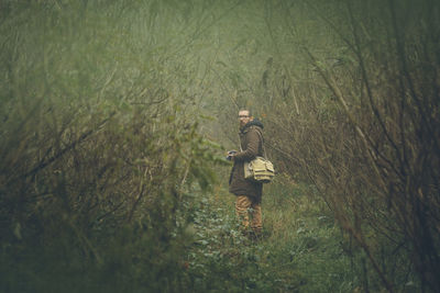 Man walking on field in forest