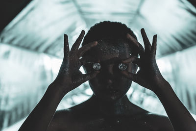 Close-up of woman covered in glitter holding diamonds 