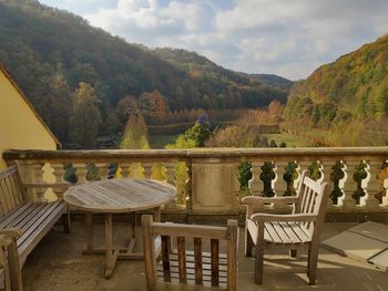View on castle weesenstein with wooden terrace and empty chairs and tables against cloudy sky