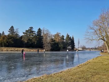 Scenic view of lake against clear blue sky