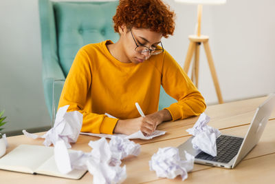 Young woman using laptop while sitting at home