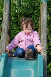 Full length of girl sitting on wood