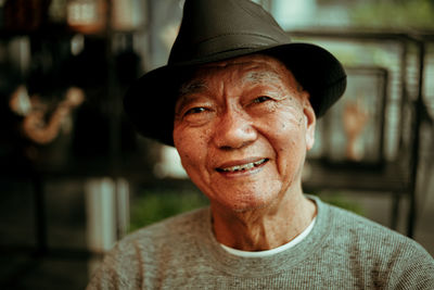 Close-up portrait of smiling senior man sitting in cafe