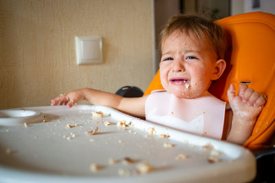 Portrait of cute baby girl on table at home