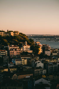 Aerial view of townscape by sea against clear sky