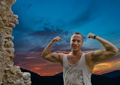 Portrait of young man standing against blue sky