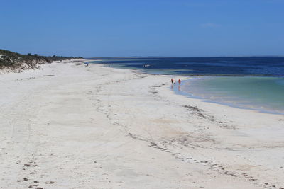 Scenic view of beach against clear blue sky