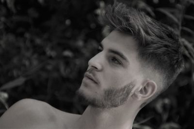 Portrait of young man looking away outdoors