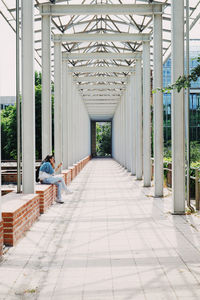 Rear view of man sitting on bridge