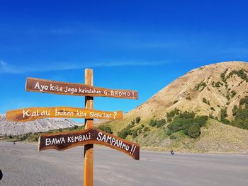 Information signs in desert against blue sky